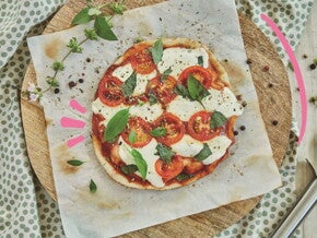 pizza margarita slim en tabla de corte junto a rebanador  Las embarazadas pueden comer pizza