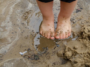 Pies de pequeño sobre agua con lodo aprende ensuciándose