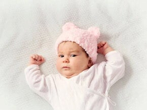 El fascinante mundo de tu bebé de 2 meses Bebé de dos meses acostada sobre la cama.