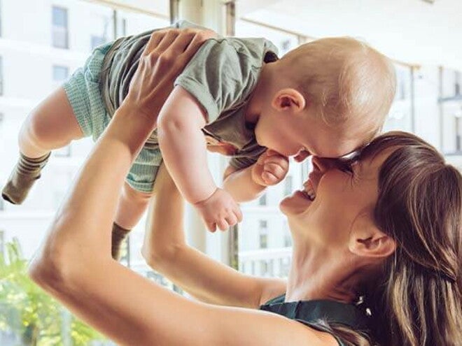 Conoce que es la curva de crecimiento y desarrollo. Mamá cargando a su bebé.